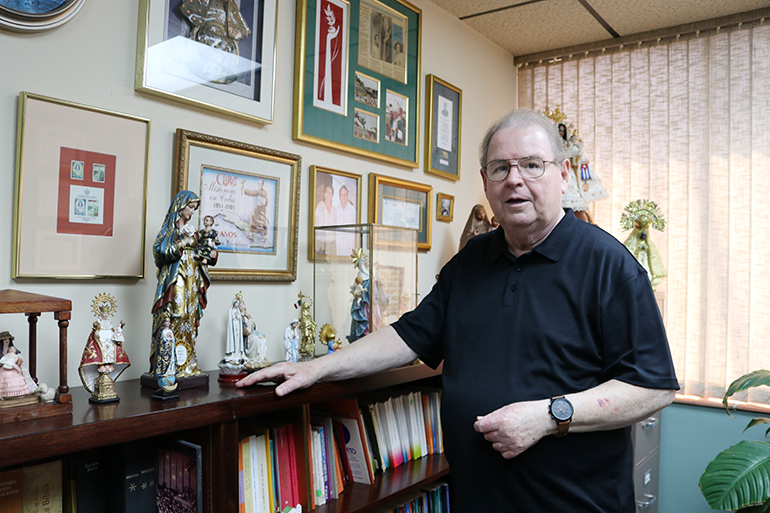 Rogelio Zelada, el custodio de la Virgen de la Caridad, posa con varias  imágenes de Vírgenes Patronas de países de America Latina, en su oficina del Centro pastoral.