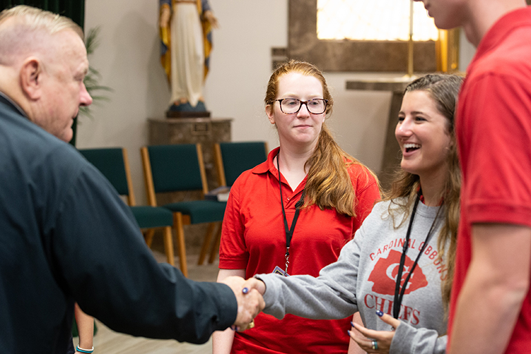 Archbishop Thomas Wenski greets Cardinal Gibbons High School student representatives after arriving on campus Aug. 22 to celebrate Mass for the opening of the school year.