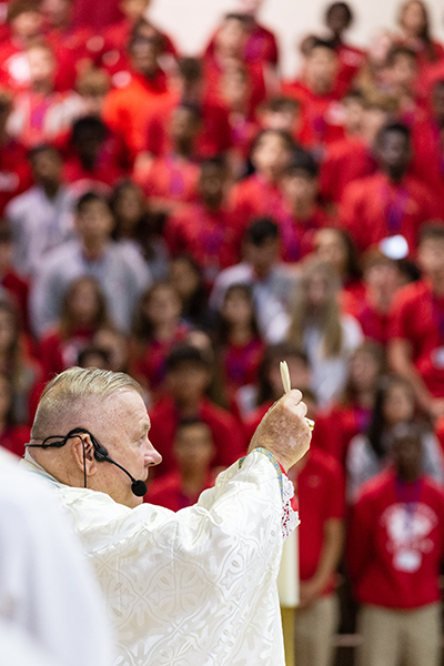 Archbishop Thomas Wenski elevates the consecrated host while celebrating Mass for the opening of the school year at Cardinal Gibbons High School Aug. 22, feast of the Queenship of Mary.