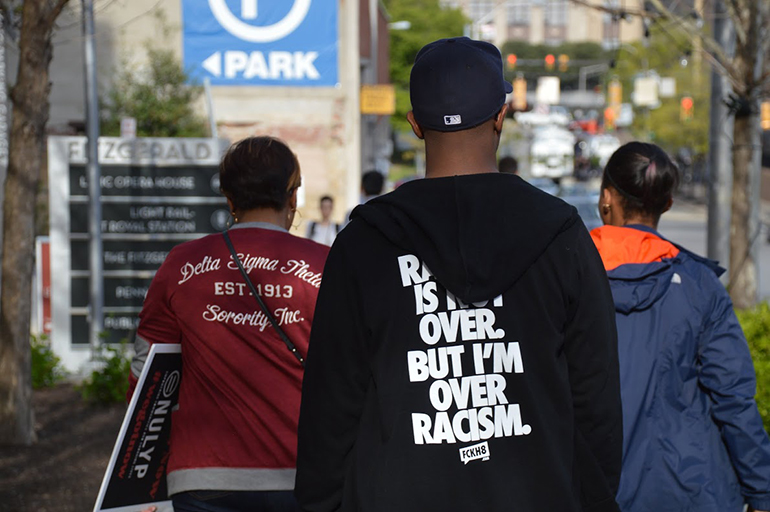 A local wears an "I'm over racism shirt" on the streets of Baltimore, Maryland on May 1, 2015, in light of the death of Freddy Gray, a young African-American man who was reportedly killed by Baltimore police in April.