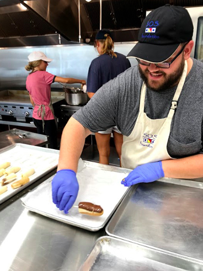 Seminarian Sebastian Grisales helps with food preparation at the SOS Callahan Community Kitchen, one of several outreach programs sponsored by the Basilica of St. Mary Star of the Sea in Key West. He was one of four seminarians who helped at the parish ministries last summer.