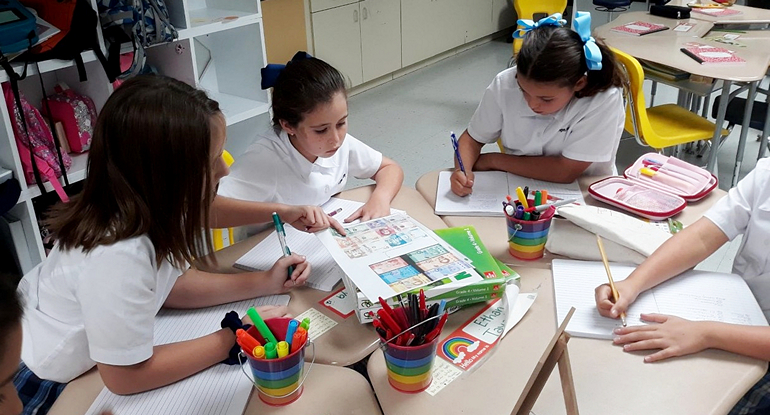 Students at St. Agnes School learn about Spanish by studying various designs of Hispanic currency.