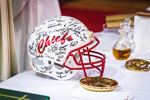 After celebrating a Mass for the opening of the school year on Aug. 22 at Cardinal Gibbons High School in Fort Lauderdale, Archbishop Thomas Wenski received a special gift from members of the school's football team, who signed a helmet for the archbishop. Area priests were also given guest passes to upcoming football games.