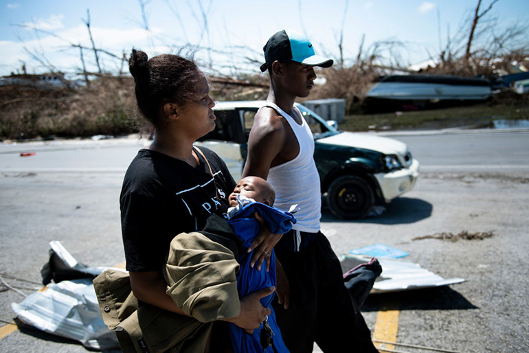 Isabel Strachan, left, walks with her son Nathiel Strachan and brother-in-law Kyreem Jonassaind after Hurricane Dorian Sept. 5, 2019, in Marsh Harbor, Great Abaco. Hurricane Dorian lashed the Carolinas with driving rain and fierce winds as it neared the US east coast Thursday after devastating the Bahamas and killing at least 20 people.