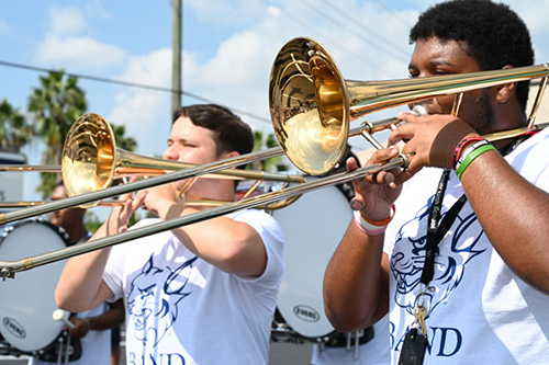 Members of St. Thomas University's marching band play at the school's first game.