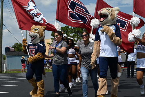 St. Thomas University's mascots, flagbearers and cheerleaders run into the field before the first football game Sept. 7.