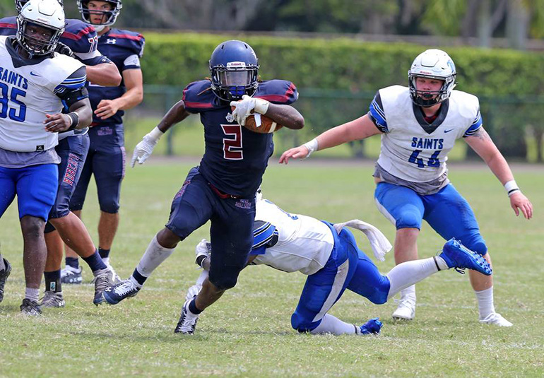 Bobcats running back Robert Armes (2) runs away from Thomas More defenders during St. Thomas University's first football game, Sept. 7.