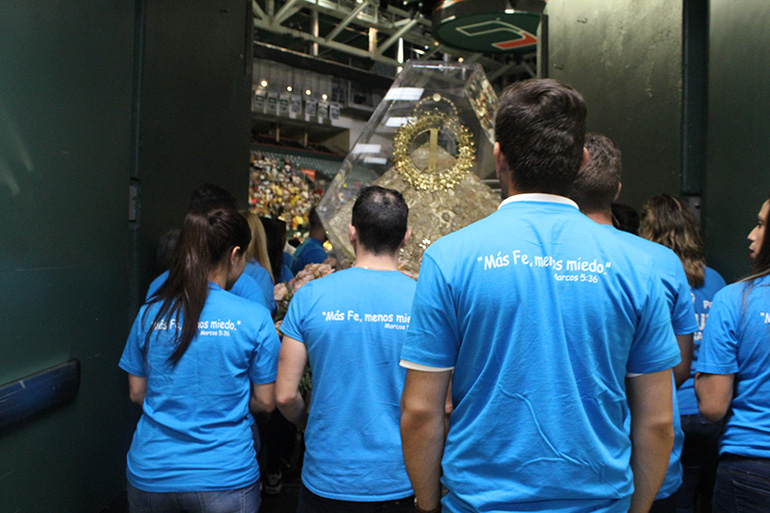 Integrantes de Caridad Joven, el grupo de jóvenes de la Ermita de la Caridad, se preparan para cargar la imagen de la patrona de Cuba en procesión en el Watsco Center de la Universidad de Miami en el día de su fiesta, el 8 de septiembre de 2019.