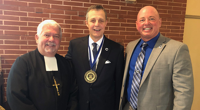 After the installation, Brother Patrick McNamara, USA provincial of the USA Marist Brothers, poses with Columbus High School's president, Thomas Kruczek, center, and school principal David Pugh.