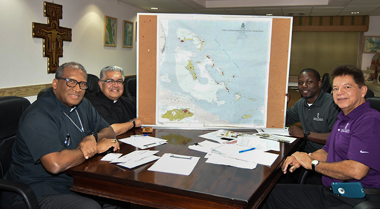 Catholic Charities in Miami is working closely with Nassau Archbishop Patrick Pinder, far left, to provide needed relief to those affected by Hurricane Dorian. Back in Sept. 17, the archbishop met with Msgr. Roberto Garza and Peter Routsis-Arroyo, front right, of Catholic Charities, as well as Marco Greenslade, Catholic Charities' director of Finance, who was born and raised in the Bahamas.