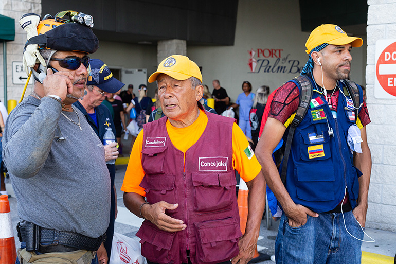 Hector Mendez of Mexico City, center, speaks to a fellow search-and-rescue volunteer after arriving at the Port of Palm Beach Sept. 18. He was among the first responders and search-and-rescue volunteers and professionals from the U.S. and Latin America who embarked on a mission in the northern Bahamas in response to the category 5 Hurricane Dorian, which slammed into the islands Sept. 1-3, causing historic devastation. The Florida-based Bahamas Paradise Cruise Line concluded its second humanitarian round trip mission by providing the transportation from Florida to Freeport, Grand Bahama, carrying some 400 volunteers and 200 visa-carrying Bahamas evacuees.