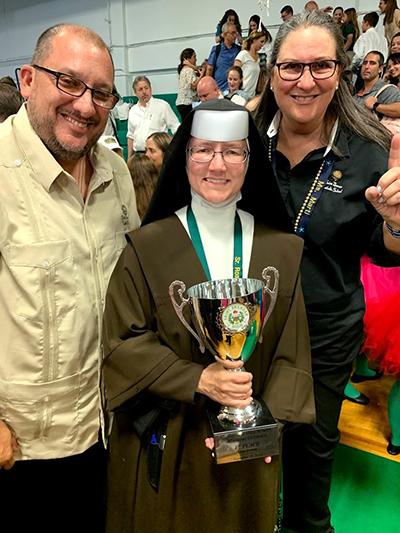 St. Theresa School faculty pose with the winning trophy for first place overall in the large school division of St. Brendan High's Academic Olympics, from left: Daniel Serrano, seventh and eighth grade teacher, Carmelite Sister Rosalie Nagy, principal, and Gloria Marti, vice principal.