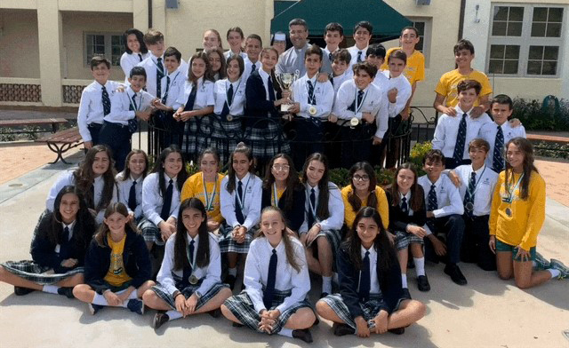 St. Theresa School students who participated in the St. Brendan High Academic Olympics, winning First Place Overall in Large Division Schools, pose with Carmelite Sister Rosalie Nagy, principal, and Father Manny Alvarez, pastor.