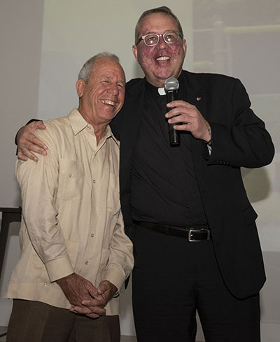 Coach Carlos Barquin gets a hug from Belen Jesuit President Father Guillermo Garcia-Tunon at the 50th anniversary celebration for Barquin's 50 years at Belen, held last April.