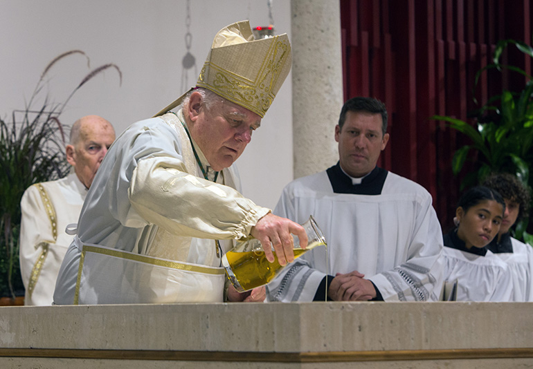 Archbishop Thomas Wenski pours oil of chrism on St. Matthew Church's new altar as he consecrates it during the parish's 60th anniversary Mass, Sept. 25, 2019.