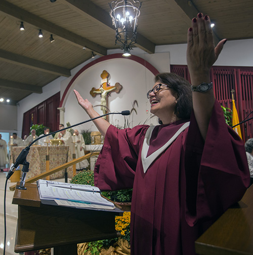 Meredith Schuster, miembro del coro, dirige la congregación en una canción durante la Misa del 60Âº. aniversario de la parroquia St. Matthew, el 25 de septiembre de 2019.