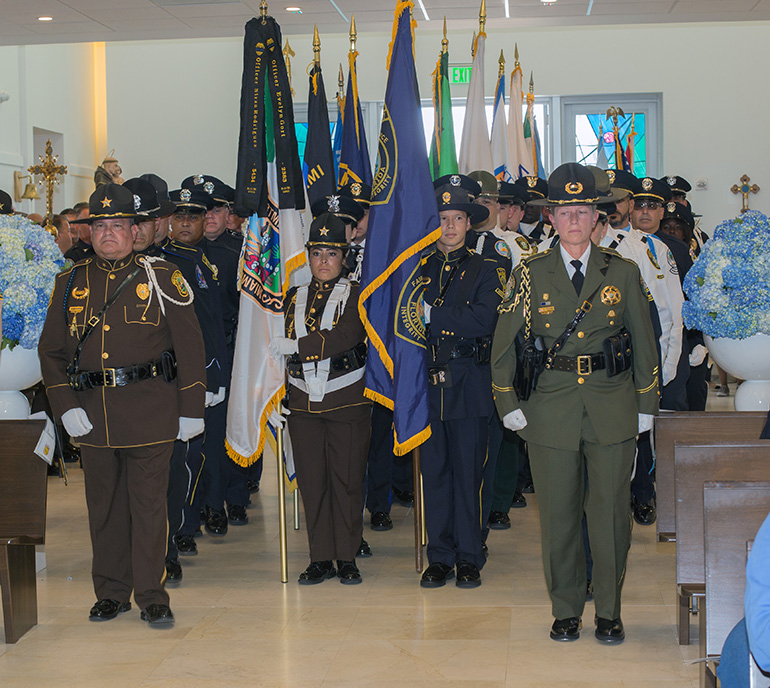 Police honor guards from various departments enter Our Lady of Guadalupe Church in Doral for the Blue Mass Sept. 27. Archbishop Thomas Wenski celebrated the Mass for the feast day of St. Michael the Archangel, patron saint of law enforcement officers.