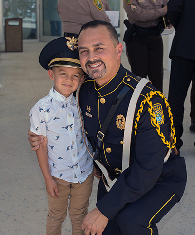 Jeronimo Lopez, 4, poses for a photo with his father, Cristian Lopez, a Medley police officer and police honor guard member, after the celebration of the Blue Mass.