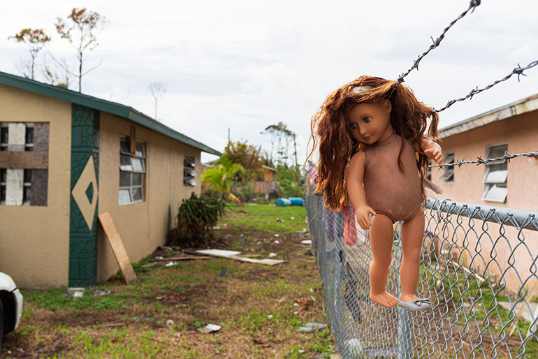 In the Hudson Estates neighborhood of Freeport, near Mary, Star of the Sea Parish, a doll is seen drying in the sun Oct. 8, more than a month following Hurricane Dorian's impact in The Bahamas. The area was heavily damaged by Dorian's storm surge-flooding throughout Grand Bahama.