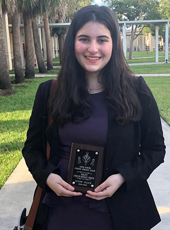 Immaculata-La Salle senior Isabella Perez holds her sixth trophy in the Lincoln-Douglas debate of the Oct. 12 competition at West Broward High School.