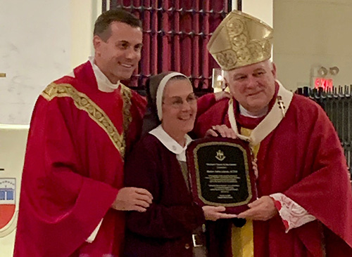 Archbishop Thomas Wenski and Msgr. David Toups, left, rector of St. Vincent de Paul Regional Seminary in Boynton Beach, recognize Mother Adela Galindo, founder of a new religious community, the Servants of the Pierced Hearts of Jesus and Mary, just before the Friends of the Seminary annual dinner Oct. 18, 2019. "The community continues to grow and flourish even beyond the Archdiocese of Miami," Archbishop Wenski said.