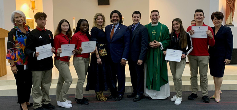 The five recipients of this year's Jorge Luis Lopez Esq. Scholarship at Msgr. Edward Pace High School pose with Jorge Luis Lopez, his wife and one of their sons (center), Pace Principal Ana Garcia (far left), Father Richard Vigoa, and Celia Rouco, director of Development at Pace.