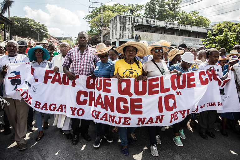 Catholic faithful demonstrate in a silent and non-violent march in Port-au-Prince against the Haitian government Oct. 22, 2019. Thousands of Catholics demanding the resignation of Haiti's president marched through the capital, becoming the latest group to join an outcry against him. They gathered outside one of the main churches in Port-au-Prince and denounced President Jovenel Moise as corrupt and incompetent. (Photo by Valerie Baeriswyl / AFP via Getty Images)