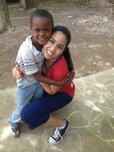 Amor en Accion missionary Janelle Jay gets a big hug from a new friend during a mission trip to the Dominican Republic.