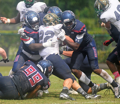 Ave Maria running back Isaac Cornewell is tackled by St. Thomas defenders Anthony Sumner (99), Micah Monds (90) and another Bobcats defender during their Mid-South Conference football game Oct. 26, 2019, at Msgr. Pace High School.