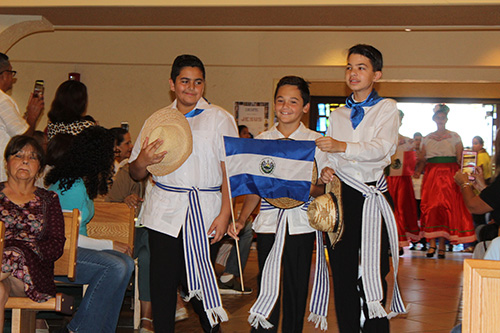 St. Kevin School students bearing the flag of El Salvador process into St. Kevin Church for the Hispanic heritage Mass.