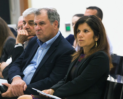 Michelle Maldonado, religious studies professor at the University of Miami, and Leonidas Bachas, dean of UM's College of Arts and Sciences, listen to Archbishop Thomas Wenski speak at a University of Miami forum on "Who Is Our Neighbor? Immigration in Light of Catholic Social Teaching," held in the Newman Alumni Center, Oct. 21, 2019.