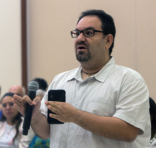 Louis Hernandez, a University of Miami alum, asks what the Catholic Church can do to unify Catholics on various political issues during a question and answer session following Archbishop Thomas Wenski's talk at a UM forum on "Who Is Our Neighbor? Immigration in Light of Catholic Social Teaching," held in the Newman Alumni Center, Oct. 21, 2019.