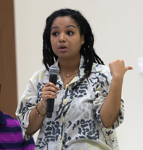 Rae Williams, a University of Miami political science major and vice president of UM's Amnesty International chapter, asks about Catholic Legal Services during the question and answer session that followed Archbishop Thomas Wenski's talk at a UM forum on "Who Is Our Neighbor? Immigration in Light of Catholic Social Teaching," held in the Newman Alumni Center, Oct. 21, 2019.