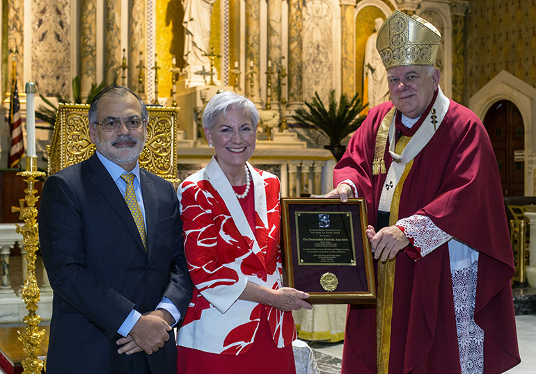 Raoul Cantero, last year's Lex Christi, Lex Amoris Award recipient, poses for a photo after presenting the 2019 award to Senior U.S. District Judge Patricia Seitz. With them is Archbishop Thomas Wenski, who celebrated the annual Red Mass of the Holy Spirit for the Miami Catholic Lawyers Guild Oct. 24, 2019 at Gesu Church, Miami.