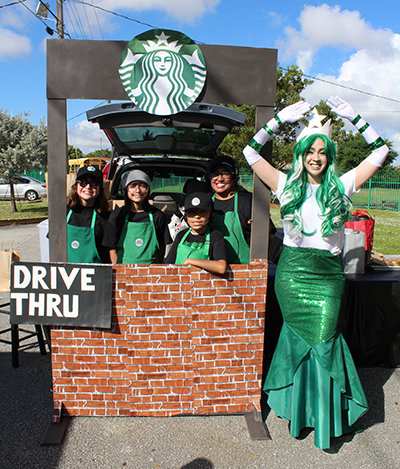 Serving up caramel macchiatos: Student baristas at a Starbucks drive-thru-themed vehicle handed out baked goods, candy, and even a few coffee beverages to adults during this year's trunk or treat at St. Michael the Archangel School. The Starbucks mermaid also greeted visitors.