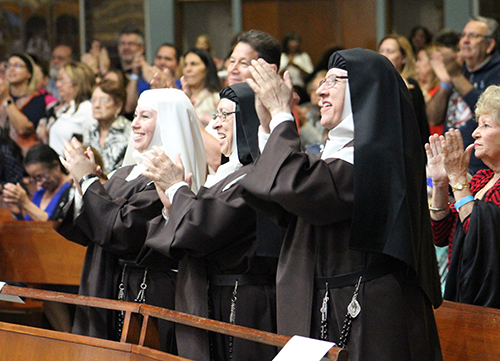 When the nuns applaud, you know it was great: From left: Discalced Carmelite novice Ashley Amalia Osorio, Mother Maricela de Jesus Maria, and Mother Mery Alba de Jesus applaud the music ministry group Jésed who performed at their contemplative benefit concert Nov. 6 at Immaculate Conception Church. The funds collected will go towards the completion of their  Monastery of the Most Holy Trinity in Homestead.