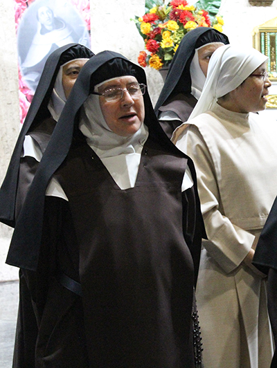 Accompanied by other Discalced Carmelites, Mother Maria Alba Mery de Jesus closes her eyes during a moment of deep prayer and song at the contemplative benefit concert held at Immaculate Conception Church in Hialeah Nov. 6 to raise funds for the remaining work of their  Monastery of the Most Holy Trinity in Homestead.