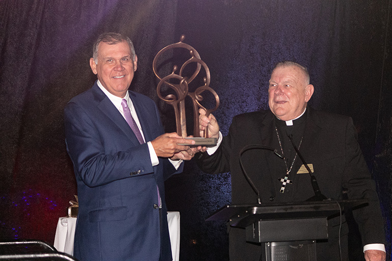 Archbishop Thomas Wenski presents former Fla. Sen. Mel Martinez with the Msgr. Bryan O. Walsh Humanitarian Award from Catholic Legal Services of the Archdiocese of Miami, in recognition of his commitment to immigration reform and justice for all people. The "Families United" reception took place Nov. 7, 2019, at the Hilton Bentley South Beach, whose managing partner, Julie Grimes, offered her staff, facilities, food and beverages free of charge.