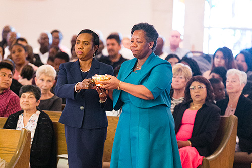 St. Elizabeth of Hungary parishioners Yolette Guerrier and Marie Augustine take up the offertory during the Mass Archbishop Thomas Wenski celebrated to mark the 60th anniversary of the trilingual and tricultural Pompano Beach parish, Nov. 17, 2019.