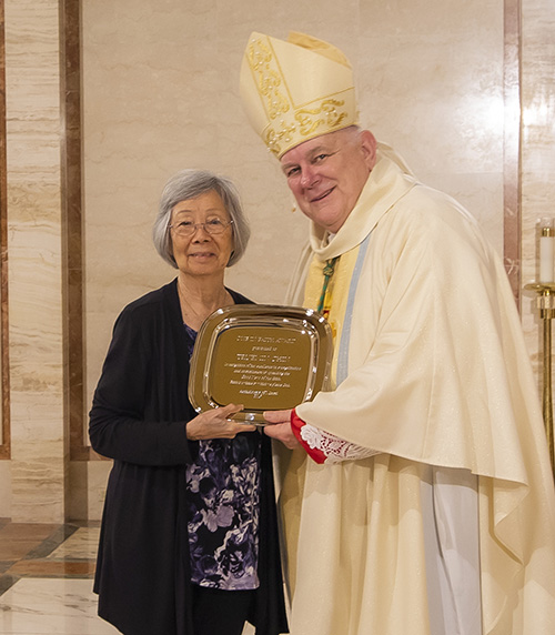 Archbishop Thomas Wenski gives Truemin Chin, from the parish of Our Lady of Guadalupe in Doral, the One in Faith award during the Thanks-for-Giving Mass celebrated at the Cathedral of St. Mary, Nov. 23, 2019.