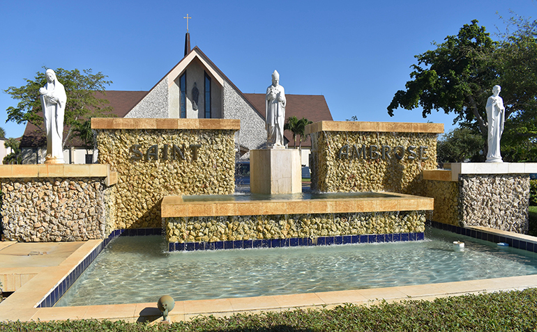 Statues of Mary, St. Ambrose and Joseph stand in front of a fountain in front of St. Ambrose Church in Deerfield Beach.