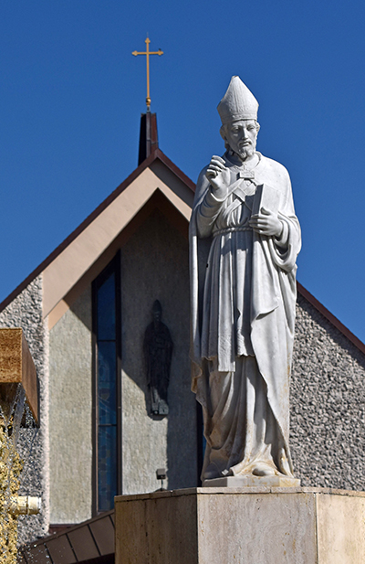 Statue of St. Ambrose stands in front of his namesake church in Deerfield Beach. A bas-relief of the saint can be seen on the church as well.