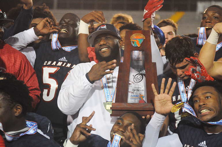 Head coach Dameon Jones and his players pose with the state-championship trophy after Chaminade-Madonna's 35-20 victory over Tallahassee Florida High Friday, Dec. 6, 2019, in the 2019 FHSAA 3A state football championship game at Gene Cox Stadium in Tallahassee. The Lions won their third consecutive state title and fifth overall.