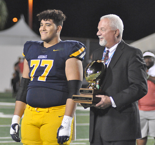 St. Thomas Aquinas offensive lineman Marlon Martinez receives the Henry O. Langston Orange Bowl Award from FHSAA commissioner George Tomyn before the school's 28-23 victory over Orlando Edgewater on Dec. 14, 2019, in the Class 7A FHSAA state football championships at Daytona Stadium in Daytona Beach. The award is given to the player on each state-final team with the best grade-point average.