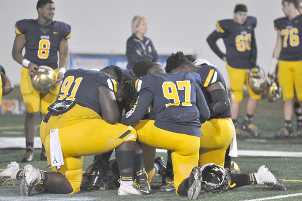 St. Thomas Aquinas defensive linemen pray before their 28-23 victory over Orlando Edgewater on Dec. 14, 2019, in the Class 7A FHSAA state football championships at Daytona Stadium in Daytona Beach. The Raiders won their state-record-tying 11th state championship.