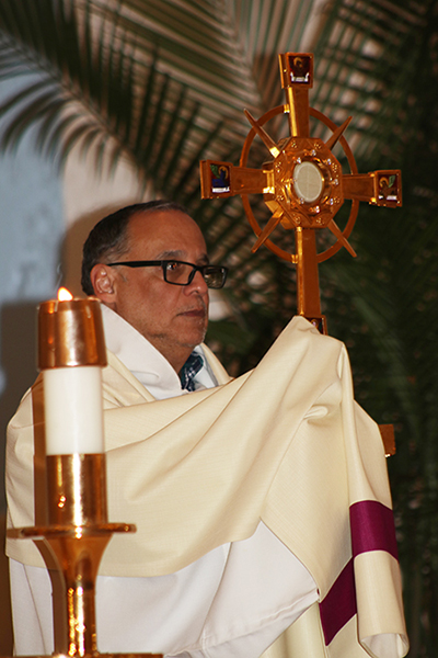 El P. Pedro Corces, vicario parroquial de Our Lady of Divine Providence, en Sweetwater, lleva el Santísimo Sacramento durante la vigilia por los jóvenes de DACA.