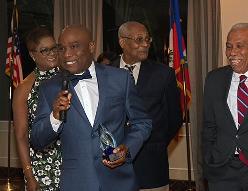 Maxo Sinal, CEO of Sinal Consulting Group, accepts his award as Haiti First board members look on, during the NGO's seventh annual Fundraising Cultural Night, Nov. 16, 2019 in Miami Shores.