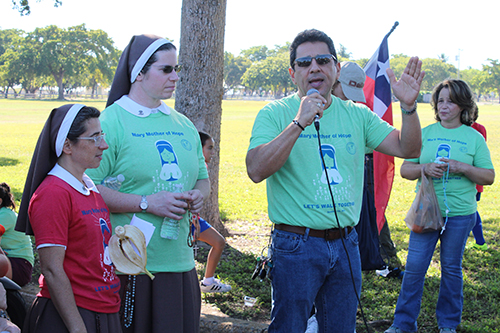 Father Juan Carlos Paguaga encourages his parishioners from St. Agnes Church to continue walking to the Shrine of Our Lady of Charity Dec. 7, 2019. To his left are Sister Maria Andrea Oliver and Sister Sarah Rose, of the Sisters of the Pierced Hearts of Jesus and Mary.