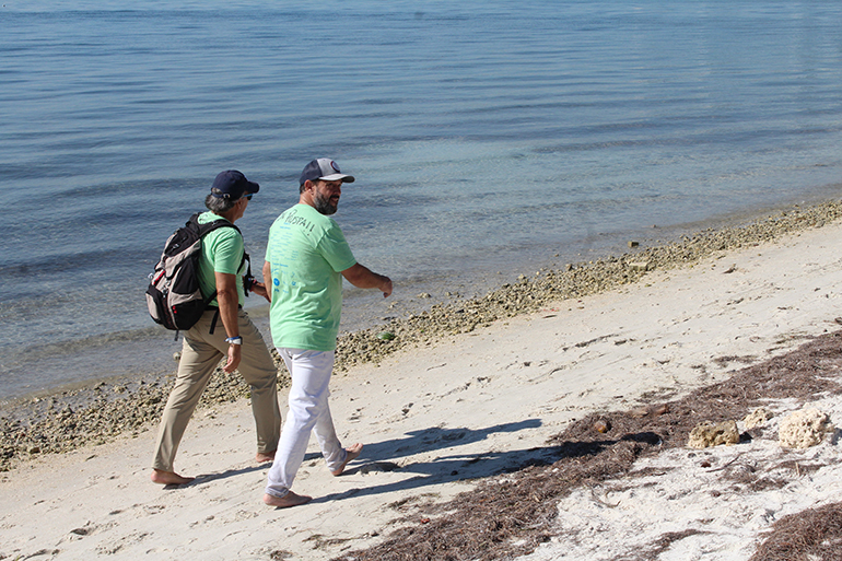 Two members of the "Barefoot Confraternity" walk on the shores of the Hobie Island Beach Park on Rickenbacker Causeway during this year's Marian pilgrimage from St. Agnes Church to the Shrine of Our Lady of Charity. To take their sacrifice to the next level, several pilgrims decided to make the trek barefoot.