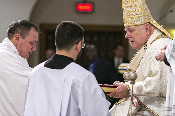 Newly ordained and vested, a visibly moved Deacon Ismer Martinez receives the Book of the Gospels from Archbishop Thomas Wenski, a sign of the deacon's role in proclaiming the word of God.




Archbishop Thomas Wenski ordained nine more permanent deacons for the Archdiocese of Miami at St. Mary Cathedral, Dec. 14, 2019.